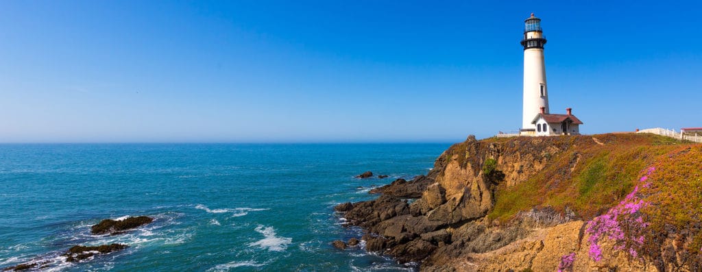 Lighthouse on cliff overlooking water in Pigeon Point, California